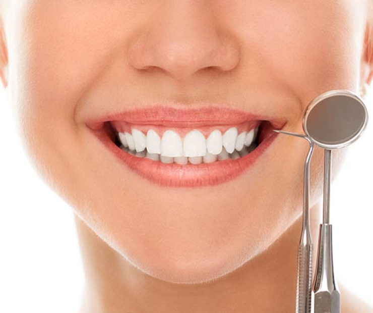 A woman is smiling while being at the dentist